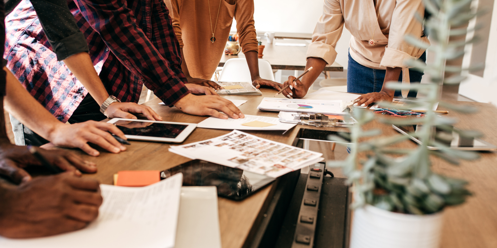 Diverse team coming together at a table to strategize.