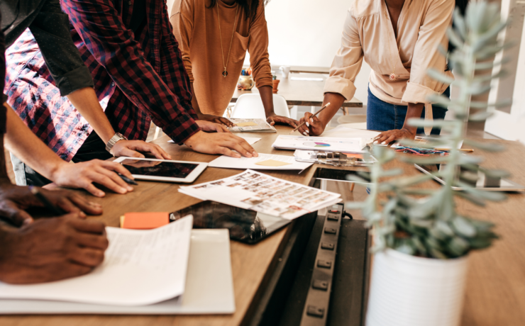 Diverse team coming together at a table to strategize.