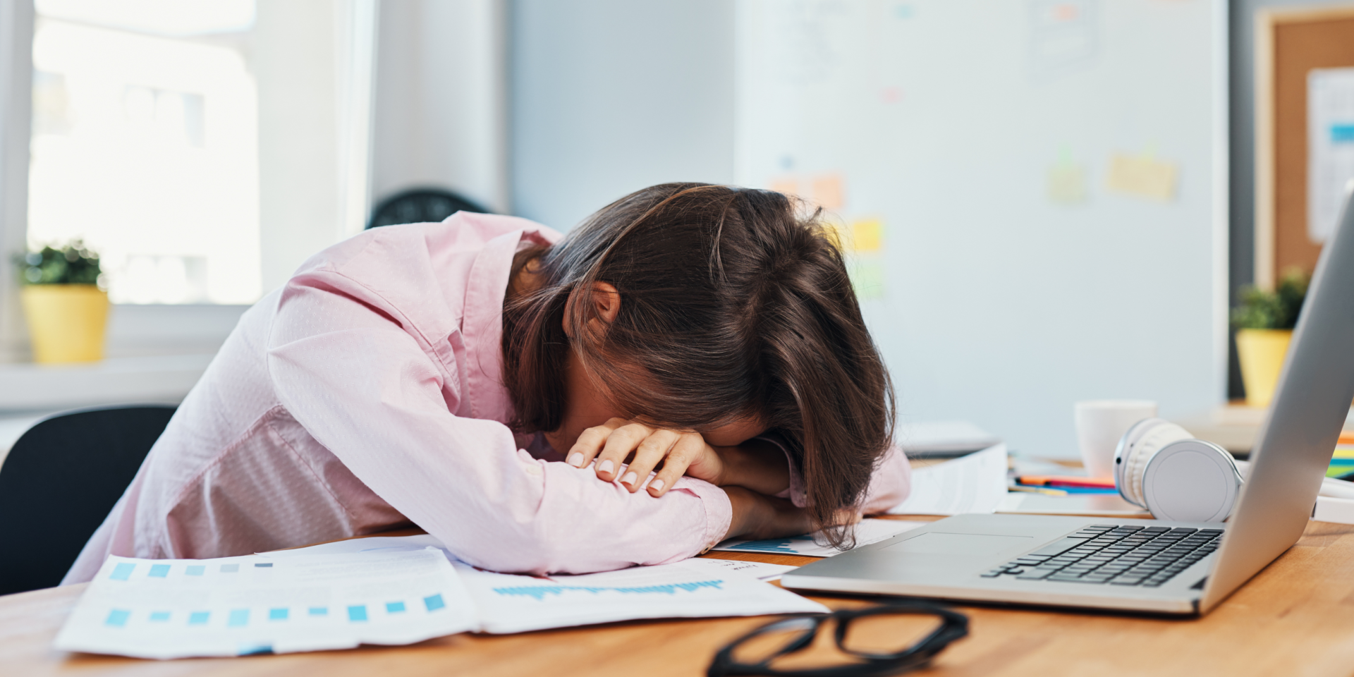 Woman tired with head on table due to quiet quitting.